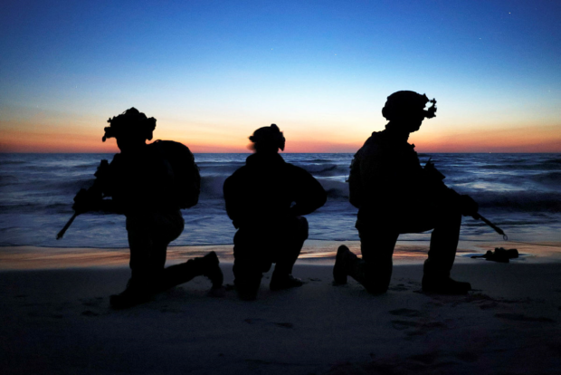 Three soldiers on a dark beach